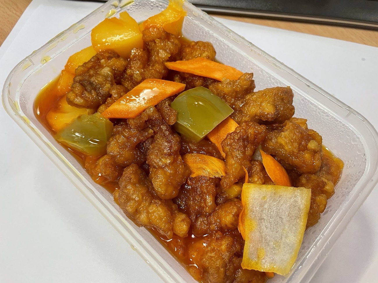 Hong Kong style sweet and sour chicken with peppers, carrot and pineapple in a takeaway tub