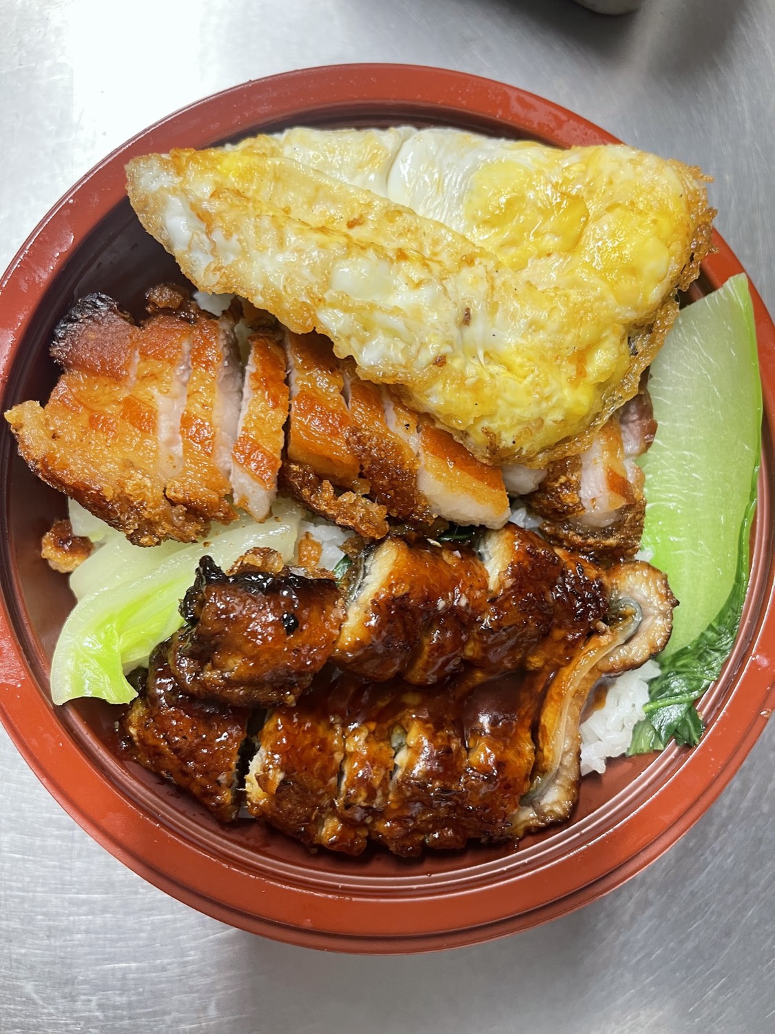 Roast pork belly and char siu chicken over egg fried rice with a fried egg and pak choi